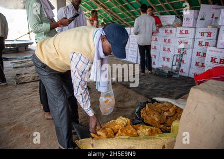 Roorkee, uttarakhand, Indien - Nov 7 2021: Mann kauft Jaggery aus der Fabrik. Produktionsstandort für Rohrzucker mit nicht zentrifugalem Einsatz. Stockfoto