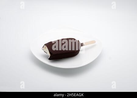 Glasierte Eiscreme auf einem Stock beißen. Stockfoto