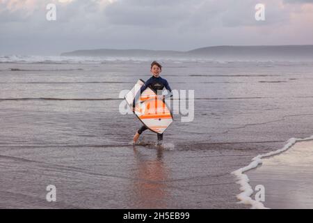 Zwölf Jahre alter Junge Bodyboarding in Westward Ho! Devon, England, Vereinigtes Königreich Stockfoto