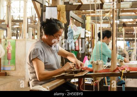 Vientiane, Laos - 14th. Februar 2018: Weber arbeiten mit traditionellen Webstühlen und Materialien bei Lao Textiles Stockfoto