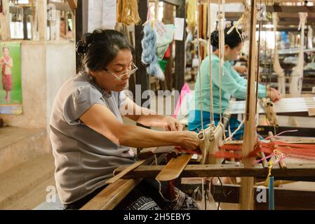 Vientiane, Laos - 14th. Februar 2018: Weber arbeiten mit traditionellen Webstühlen und Materialien bei Lao Textiles Stockfoto