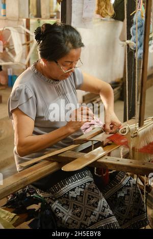 Vientiane, Laos - 14th. Februar 2018: Weber arbeiten mit traditionellen Webstühlen und Materialien bei Lao Textiles Stockfoto