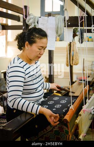 Vientiane, Laos - 14th. Februar 2018: Weber arbeiten mit traditionellen Webstühlen und Materialien bei Lao Textiles Stockfoto