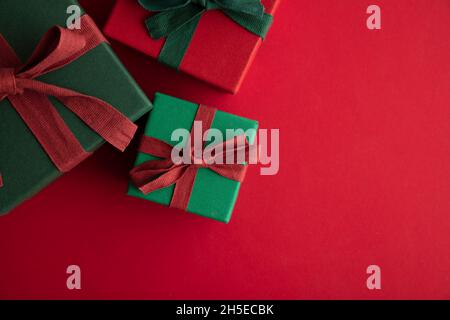 Festliche weihnachts-Geschenkbox Geschenk mit einem rustikalen Band und Schleife auf rotem Hintergrund gebunden. Ansicht von oben Stockfoto