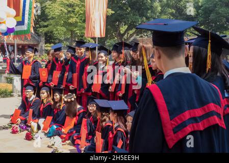 Studenten posieren für Fotos, um ihren Abschluss im Dritten Hof, Tempel der Literatur, Hanoi, Vietnam zu feiern Stockfoto