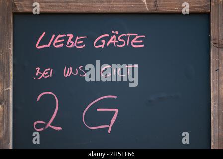 Stuttgart, Deutschland. November 2021. Vor einem Restaurant im Stuttgarter Westen hängt ein Schild mit der Aufschrift "Liebe Gäste, hier gilt 2G". Sollte in Baden-Württemberg die sogenannte Alarmstufe in Kraft treten, sieht die Corona-Verordnung landesweit die 2G-Regel vor, beispielsweise in Restaurants, Museen, auf Ausstellungen und den meisten anderen öffentlichen Veranstaltungen. Quelle: Marijan Murat/dpa/Alamy Live News Stockfoto