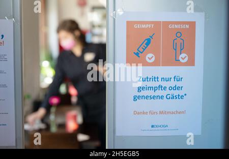 Stuttgart, Deutschland. November 2021. An der Eingangstür eines Restaurants im Stuttgarter Westen hängt ein Schild mit der Aufschrift „Eintritt nur für geimpfte oder wiedergeborene Gäste“. Sollte in Baden-Württemberg die sogenannte Alarmstufe in Kraft treten, sieht die Corona-Verordnung landesweit die 2G-Regel vor, beispielsweise in Restaurants, Museen, auf Ausstellungen und den meisten anderen öffentlichen Veranstaltungen. Quelle: Marijan Murat/dpa/Alamy Live News Stockfoto