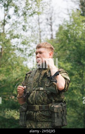 Voll ausgestattete Militärangehörige mit automatischen Waffen, die sich bereit machen, Airsoft-Strikeball zu spielen Stockfoto