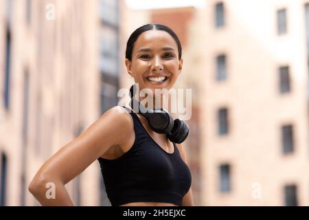 Fröhliche Junge Frau In Sportswear Posiert Im Freien Während Des Fitnesstrainings Stockfoto