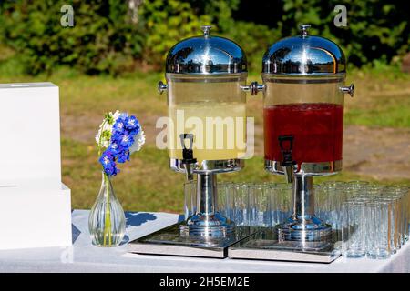 Glasgläser mit erfrischender Limonade und leere Weingläser an einem Hochzeitsbankett, Süßigkeitenbar. Weicher, selektiver Fokus. Stockfoto