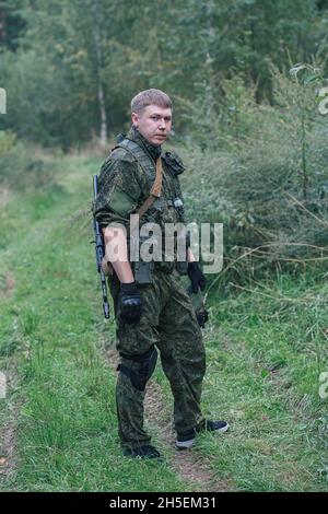 Voll ausgestattete Militärangehörige mit automatischen Waffen, die sich bereit machen, Airsoft-Strikeball zu spielen Stockfoto