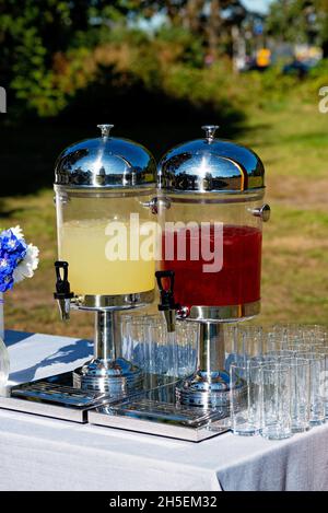 Glasgläser mit erfrischender Limonade und leere Weingläser an einem Hochzeitsbankett, Süßigkeitenbar. Weicher, selektiver Fokus. Stockfoto