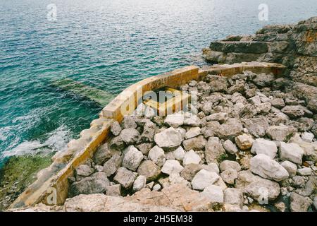 Große Felsbrocken und Reste eines Steinzauns im Meer. Montenegro Stockfoto