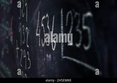 Tafel mit primären mathematischen Formeln, geschrieben mit Kreide. Konzept der Kindererziehung. Selektiver Fokus Stockfoto