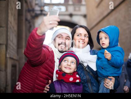 Mama und Papa mit ihren kleinen Kindern machen Selfie Stockfoto