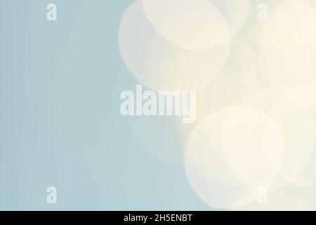 Blauer pastellfarbener Hintergrund mit gelben Girlande-Lichtern Bokeh. Stockfoto