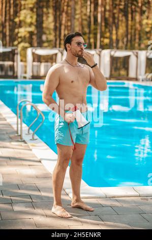 Ein männlicher Rettungsschwimmer warnt die Besucher vor einer Notsituation Stockfoto