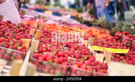 Rote Erdbeeren auf einem Wochenmarkt. Angeboten in Tabletts, süß und lecker. Stockfoto