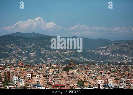 Bhaktapur, Bagmati, Nepal. November 2021. Nepals höchster Nyatapola-Tempel vom Bhaktapur der Durbar-Platz ist am Dienstagnachmittag von einer Bergstation am Stadtrand des Bhaktapur-Bezirks aus gegen die Langtang-Himalaya-Bergkette abgebildet. Mit erhöhter Sicht nach einigen Tagen des Abfalls im AQI, wird der Himmel des Kathmandu-Tals wieder von Dunst befreit, der aufgrund verschiedener menschlicher Aktivitäten entzündet wurde. Quelle: Amit Machamasi/ZUMA Wire/Alamy Live News Stockfoto