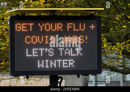 Bridport, Dorset, Großbritannien. November 2021. Elektronisches Schild neben der A35 in Bridport in Dorset, das die Menschen auffordert, sich vor dem Winter eine Grippe und Covid-Jabs zu erkranken. Bildnachweis: Graham Hunt/Alamy Live News Stockfoto