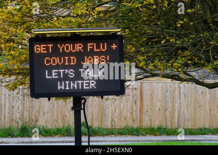 Bridport, Dorset, Großbritannien. November 2021. Elektronisches Schild neben der A35 in Bridport in Dorset, das die Menschen auffordert, sich vor dem Winter eine Grippe und Covid-Jabs zu erkranken. Bildnachweis: Graham Hunt/Alamy Live News Stockfoto