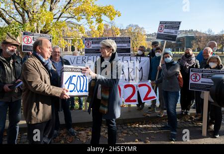 Stuttgart, Deutschland. November 2021. Vertreter von Bürgerinitiativen gegen Fluglärm demonstrieren im Schlossgarten vor dem landtag mit Transparenten gegen Fluglärm, der in ihren Gemeinden durch eine Änderung der Start- und Landestrecke entstehen würde. Links steht der Sprecher der Bürgerinitiativen, Rolf Keck, der der staatlichen lärmschutzbeauftragten Elke Zimmer (M) eine Unterschriftenbox übergibt. Über 15,000 Menschen haben eine Petition gegen die Änderung der Flugbahn unterzeichnet. Quelle: Bernd Weißbrod/dpa/Alamy Live News Stockfoto