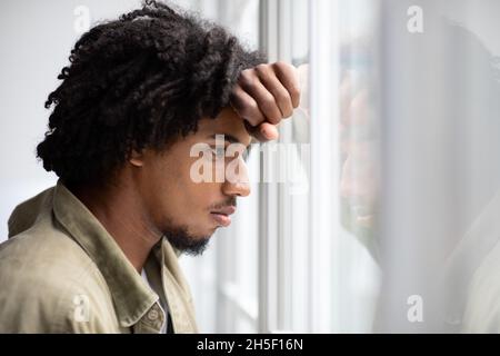 Depression-Konzept. Porträt Eines Nachdenklichen Aufgeregten Jungen Schwarzen Mannes, Der Aus Dem Fenster Schaut Stockfoto