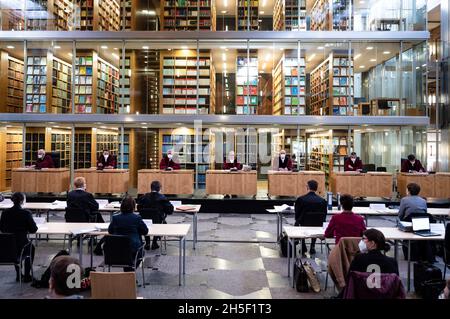 09. November 2021, Nordrhein-Westfalen, Münster: Die Richter des Bundesverfassungsgerichts Nordrhein-Westfalen sowie Vertreter der Klägerstädte sitzen corona im großen Foyer des Gerichts mit Blick auf die Bibliothek des Hauses. Die Städte Bielefeld, Dortmund, Düsseldorf, Duisburg, Essen, Gelsenkirchen und Köln klagen über zusätzliche Aufgaben aufgrund des seit 2017 geltenden Prostitutionsschutzgesetzes. Erste mündliche Anhörung der neuen Präsidentin Barbara Dauner-lieb (M). Foto: Bernd Thissen/dpa Stockfoto