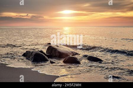 Goldener Sonnenuntergang über dem Strand in Miedzyzdroje, Polen. Stockfoto