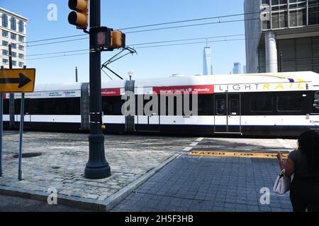 KOPFSTEINPFLASTERSTRASSE: Die New Jersey Transit-Stadtbahn fährt durch die alten Kopfsteinpflasterstraßen von Jersey City. Stockfoto