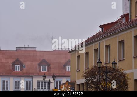 Der Rauch aus dem Kamin eines Kohleofens in einem alten Gebäude an einem düsteren Herbsttag. Stockfoto