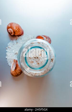 Glasbehälter mit Meersalz auf hellem Küchenhintergrund. Stockfoto