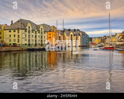 Die schönen farbigen Gebäude entlang des Brosundet-Kanals. Der Kanal verbindet die südliche Hafenfront mit dem inneren Teil der Ålesund-Straße. Stockfoto