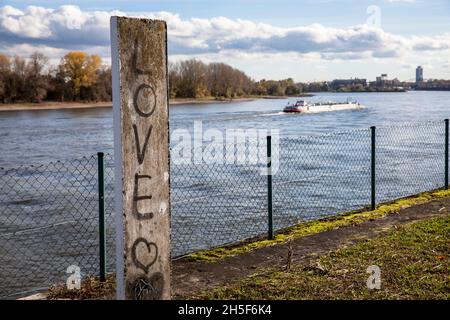 Graffiti (Love) auf einer Steinsäule am Rheinufer im Stadtteil Niehl, Köln, Deutschland. Graffiti auf einer Steinsaeule am Rheinufer Stockfoto