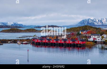 Traditionelle Fischerhäuser mit den großen hölzernen Pyramidengestellen, die hjell zum Trocknen von Stockfisch genannt werden. Aufgenommen in Svolvaer auf dem Lofoten-Archipel. Stockfoto