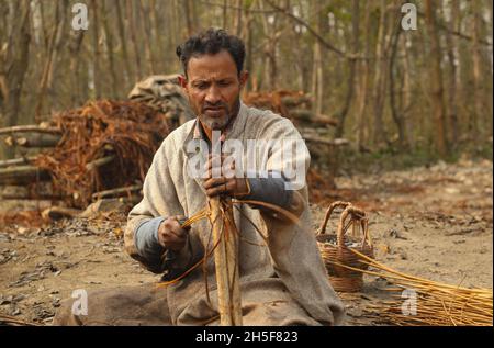 Srinagar, Jammu Und Kaschmir, Indien. November 2021. Am Stadtrand von Srinagar schälen Dorfbewohner aus Kaschmir die Haut von Korbstäben. Wicker wird für die Herstellung von traditionellen Feuerstellen namens kangri in kaschmir verwendet. Kashmiris verwenden diese traditionellen Feuerköpfe, um sich in den schweren Wintermonaten, wenn die Temperatur auf minus 20 abgeht, warm zu halten. Kangri besteht aus Ton und Zweigen, in denen heiße Kohle gehalten wird. (Bild: © Sajad HameedZUMA Press Wire) Stockfoto