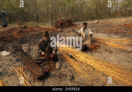 Srinagar, Jammu Und Kaschmir, Indien. November 2021. Am Stadtrand von Srinagar schälen die Dorfbewohner von Kashmiri die Haut von Korbstäben. Wicker wird für die Herstellung von traditionellen Feuerstellen namens kangri in kaschmir verwendet. Kashmiris verwenden diese traditionellen Feuerköpfe, um sich in den schweren Wintermonaten, wenn die Temperatur auf minus 20 abgeht, warm zu halten. Kangri besteht aus Ton und Zweigen, in denen heiße Kohle gehalten wird. (Bild: © Sajad HameedZUMA Press Wire) Stockfoto