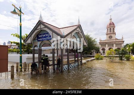 Bangkok, Thailand. November 2021. Menschen sehen, wie sie vor der Kirche von Santa Cruz durch das Flutwasser laufen.der Chao Phraya Fluss ist überflutet, beeinflusst durch starke Regenfälle, die die Kudi Chin Gemeinschaft verursachen und viele niedrig gelegene Gebiete entlang des Chao Phraya Flusses überflutet haben. (Foto: Phobthum Yingpaiboonsuk/SOPA Images/Sipa USA) Quelle: SIPA USA/Alamy Live News Stockfoto