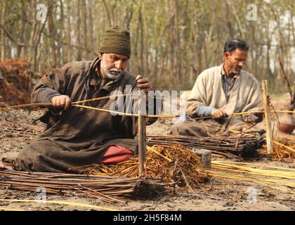 9. November 2021, srinagar, jammu und kashmir, indien: Die Bewohner von Kashmiri schälen am Stadtrand von Srinagar die Haut von Korbstäben. Wicker wird für die Herstellung von traditionellen Feuerstellen namens kangri in kaschmir verwendet. Kashmiris verwenden diese traditionellen Feuerköpfe, um sich in den schweren Wintermonaten, wenn die Temperatur auf minus 20 abgeht, warm zu halten. Kangri besteht aus Ton und Zweigen, in denen heiße Kohle gehalten wird. (Bild: © Sajad HameedZUMA Press Wire) Stockfoto