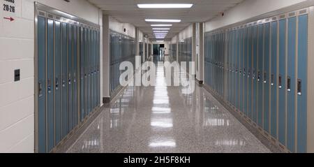 Der Flur der amerikanischen High School ist mit Schließfächern und Lichtern auf dem Boden gesäumt Stockfoto