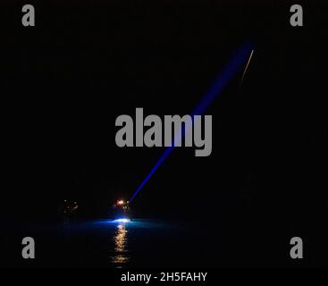 Pensecola, Vereinigte Staaten Von Amerika. November 2021. Pensecola, Vereinigte Staaten von Amerika. 08. November 2021. Ein Rettungshubschrauber strahlt Licht auf die Raumsonde SpaceX Crew Dragon Endeavour, nachdem sie im Golf von Mexiko am 8. November 2021 vor der Küste von Pensecola, Florida, abgespritkt wurde. Die Kapsel trug die SpaceX Crew-2 NASA-Astronauten Shane Kimbrough, Megan McArthur, JAXA-Astronaut Aki Hoshide und ESA-Astronaut Thomas Pesquet von der Internationalen Raumstation zur Erde zurück. Quelle: Aubrey Gemignani/NASA/Alamy Live News Stockfoto