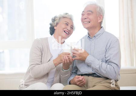 Glückliches altes Paar, das Milch trinkt Stockfoto