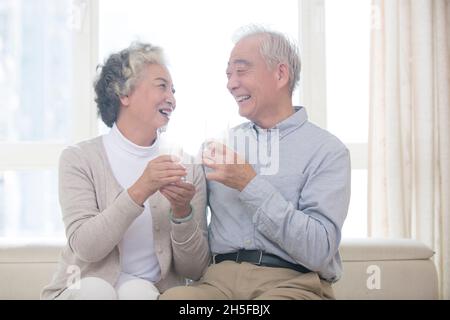Glückliches altes Paar, das Milch trinkt Stockfoto