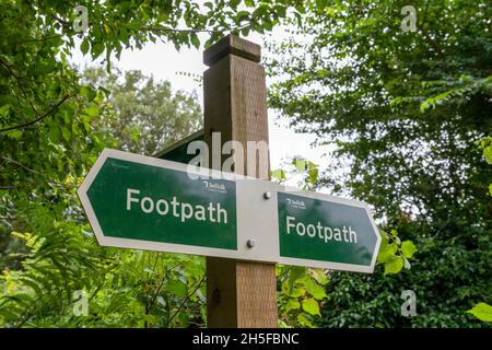 Öffentliches Wanderwegschild mit drei Richtungen auf einem neuen Holzpfosten mit Kunststoff-Richtungs-Schilder Stockfoto