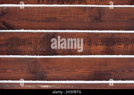 Holzzaunhintergrund mit auf den Bretter liegendem Schnee Stockfoto