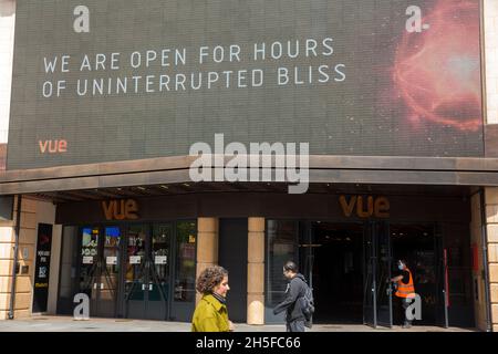 Die Menschen kommen an einer Nachricht vorbei, die über den offenen Türen eines Vue-Kinos in London angezeigt wird, da Innenräume wie Museen und Kinos wieder geöffnet werden dürfen. Stockfoto