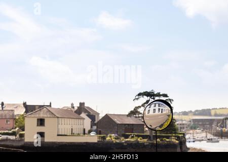 Konvexer Spiegel auf der Straße, um den entgegenkommenden Verkehr zu sehen, der ein Gebäude in Kinsale, County Cork, Irland, widerspiegelt Stockfoto