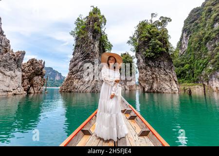 Reisefrau sitzt auf dem Boot in der Nähe der berühmten drei Felsen im Khao Sok Park, Thailand Stockfoto