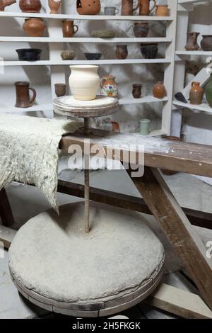 Töpferwerkstatt Studio, weißer Tontopf steht auf einem Töpferrad, vertikales Foto Stockfoto