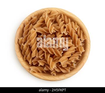 Wolegrain fusilli Pasta aus Hartweizen in Holzschale isoliert auf weißem Hintergrund mit Clipping-Pfad und volle Schärfentiefe. Draufsicht. Flach liegend. Stockfoto